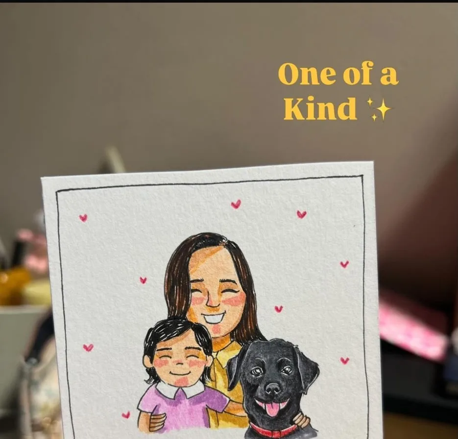 A finished caricature of a mother, her daughter and their black dog, drawn in ink and watercolour