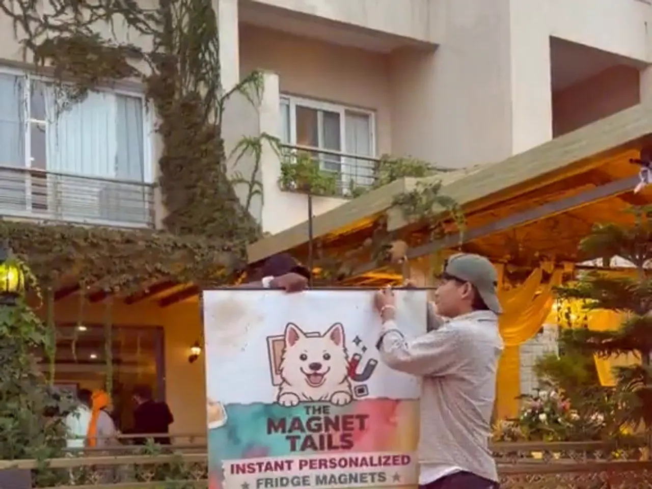 The stall banner going up in the venue courtyard while the counter is set