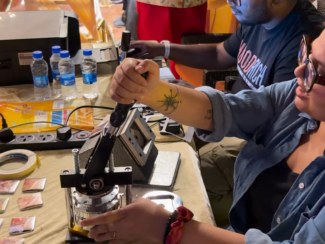 A crew member working the press while guests wait at the counter